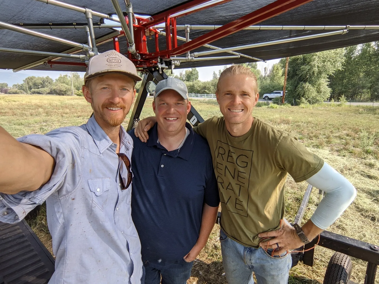 Three people standing beneath irrigation equipment at 3 Springs.