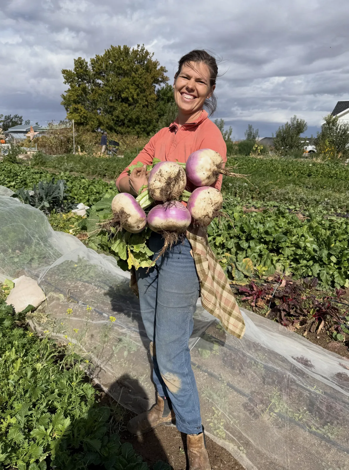 A farmer holding freshly harvested vegetables at Red Acre Farm.