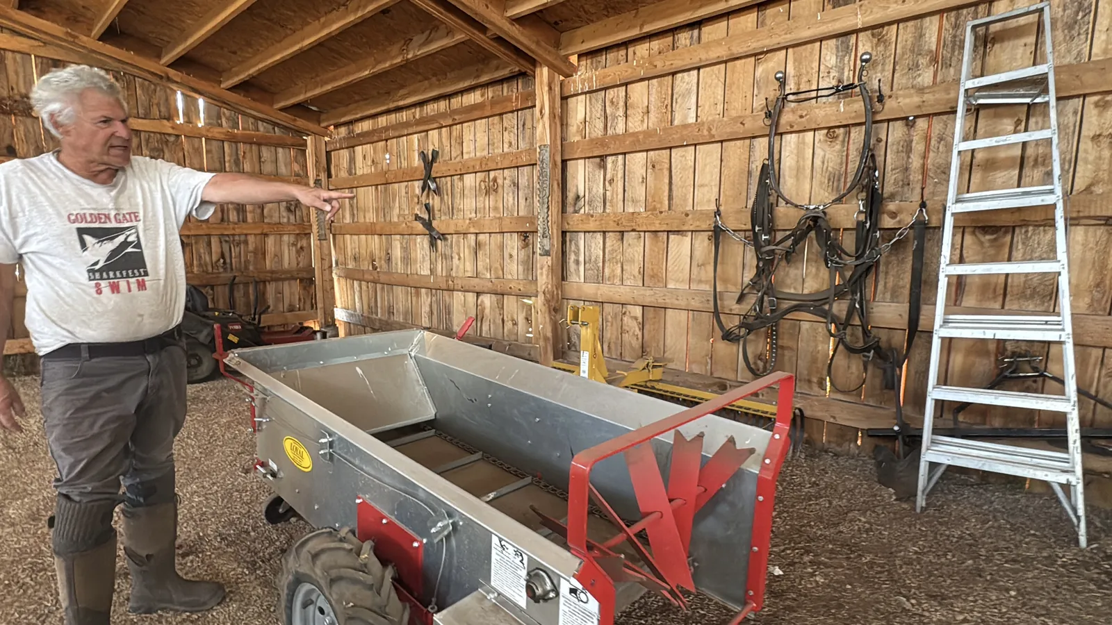 Stephen showing farm equipment inside the barn at Splendor Valley Farms.