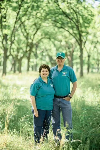Gene and Eileen standing together in the pecan orchard at Yegua Creek Farms.