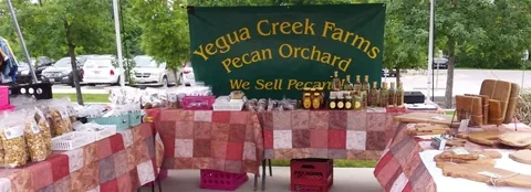 Pecan products and the Yegua Creek Farms sign at a market stand.